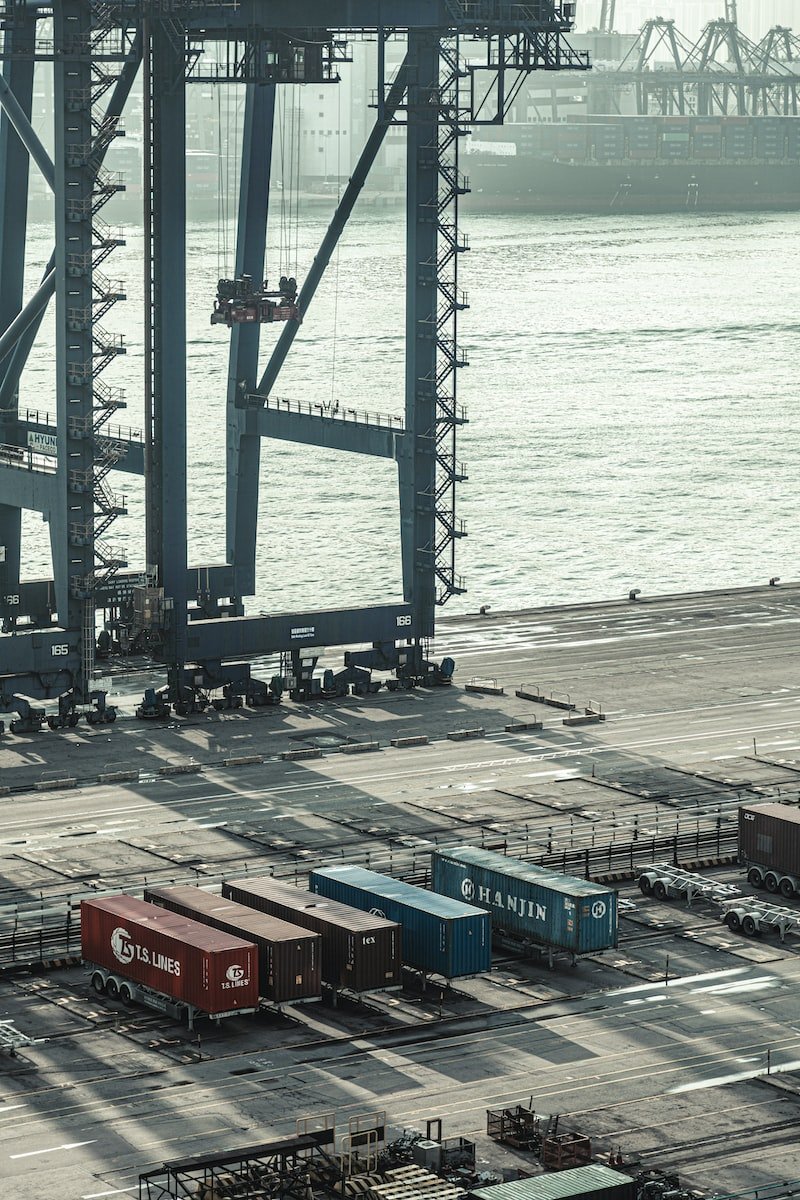 blue and red cargo containers near body of water during daytime